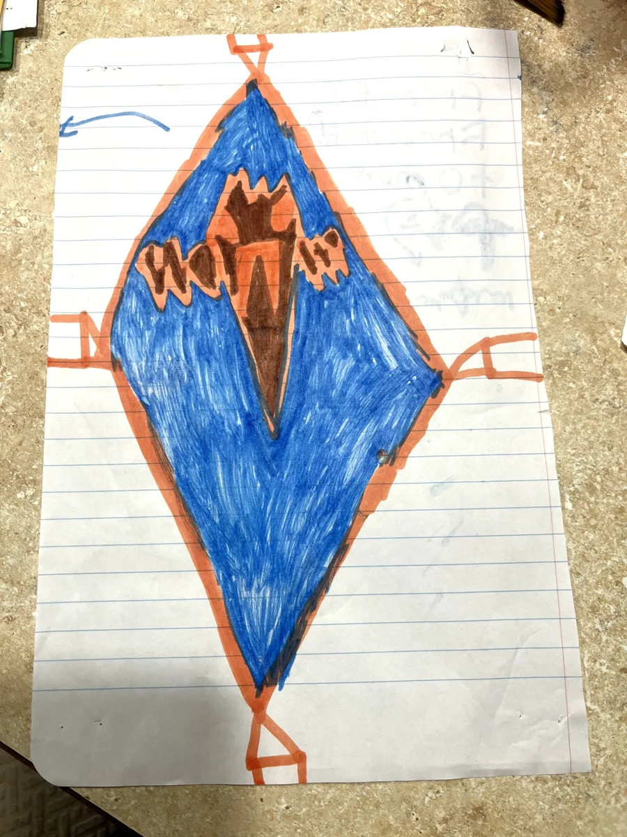 The grandson's blue and orange marker drawing on lined notebook paper