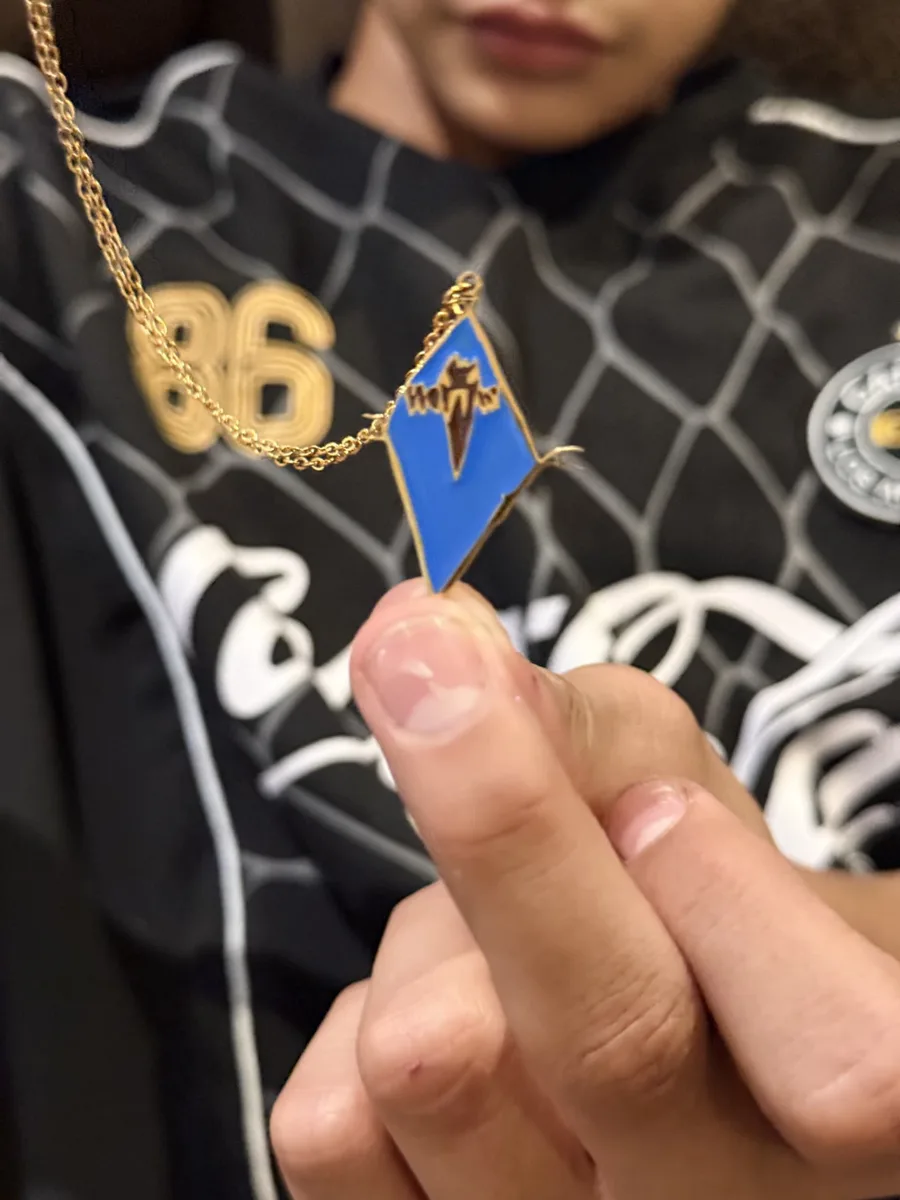 The colourful necklace held up between fingertips